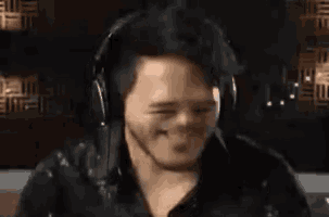 a man wearing headphones is making a funny face with his mouth wide open .