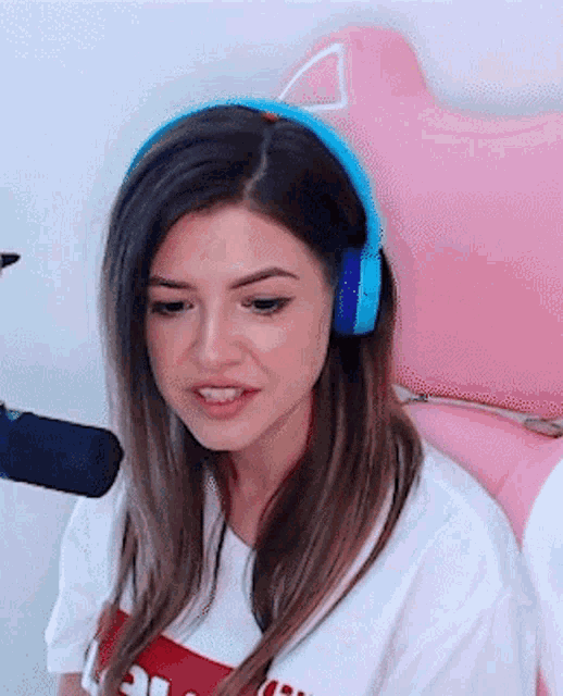 a woman wearing headphones is sitting in a pink chair