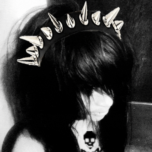 a black and white photo of a woman wearing a headband with spikes on it