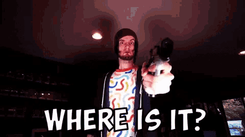 a man is pointing a gun at the camera with the words " where is it " below him