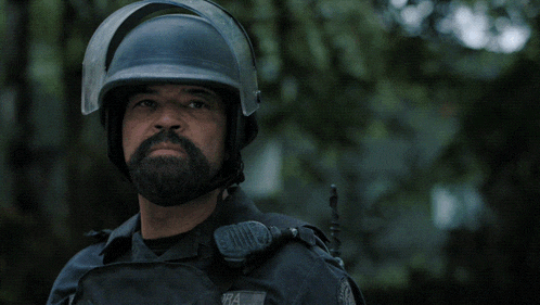 a man with a beard wearing a helmet with the words now make your choice behind him