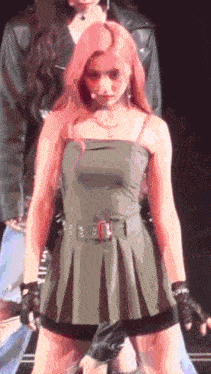 a woman in a green dress is standing on a stage with a man in a leather jacket behind her .