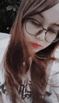 a woman wearing glasses and a t-shirt that says ' king ' on it