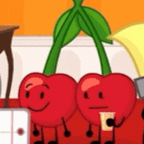two cherries are sitting next to each other on a red couch .
