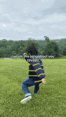 a person in a striped sweater is standing in a grassy field with the words i wrote this song about you