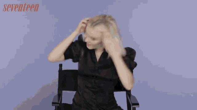 a woman in a black dress is sitting in a director 's chair with the word seventeen behind her