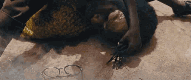 a person is laying on the ground with a pair of glasses on the ground .