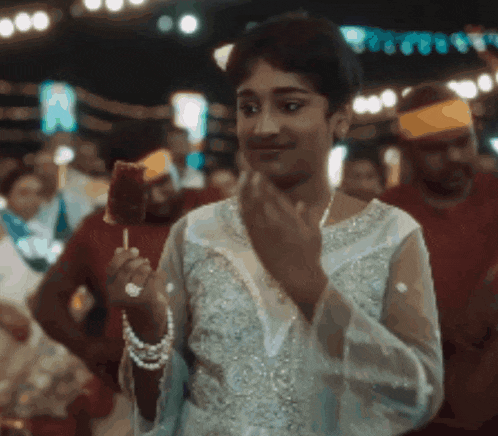 a woman in a white dress is eating ice cream