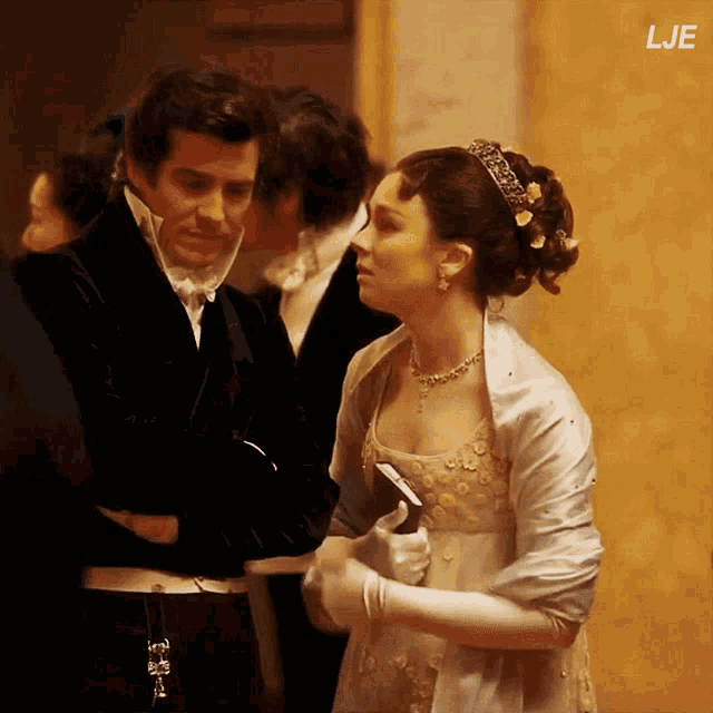 a man in a tuxedo and a woman in a white dress are standing next to each other
