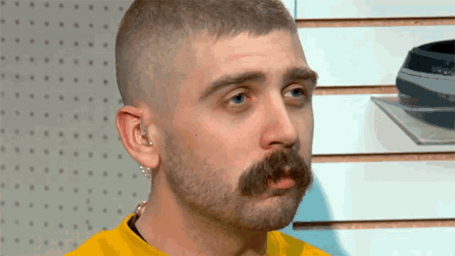 a man with a beard and mustache is wearing a yellow t-shirt
