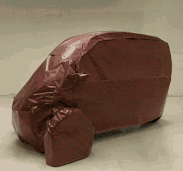 a red car is wrapped in a red plastic wrap