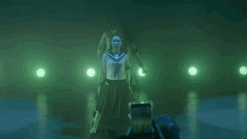 a group of dancers are performing on a stage with green lights behind them
