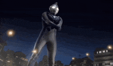 a man in a superhero costume stands in front of a city at night
