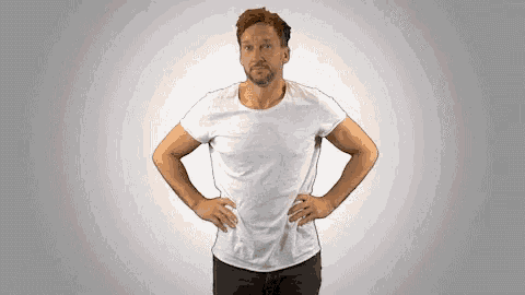a man with his hands on his hips is wearing a white t-shirt