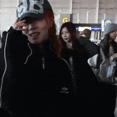 a woman wearing a hat that says balenciaga is smiling