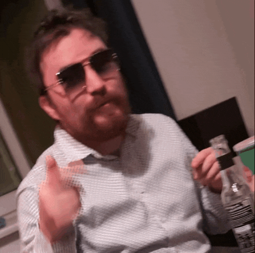 a man with a beard wearing sunglasses holds a bottle