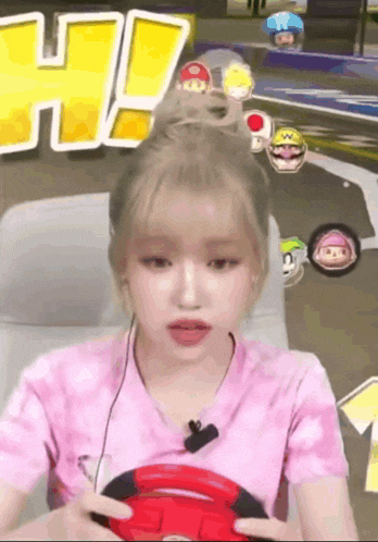 a girl in a pink shirt is playing a video game while wearing headphones
