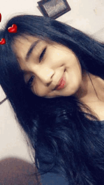 a girl with long black hair and red hearts on her hair