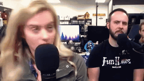 a man wearing a fun haus shirt stands next to a woman holding a microphone