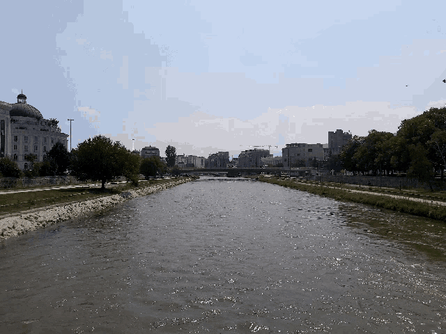 a river runs through a city with a bridge in the distance