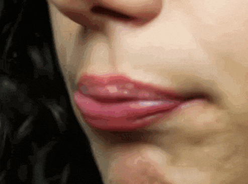 a close up of a woman 's lips with a black background
