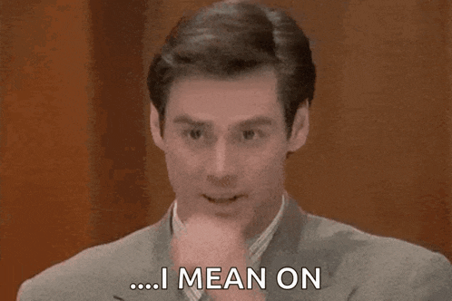 a man in a suit is saying `` i mean on '' while holding his hand to his chin .