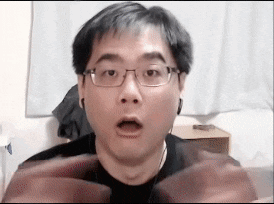 a man wearing glasses and earbuds is making a funny face .