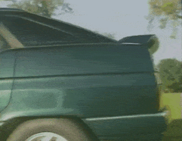 a close up of the back of a green car with a license plate that says am