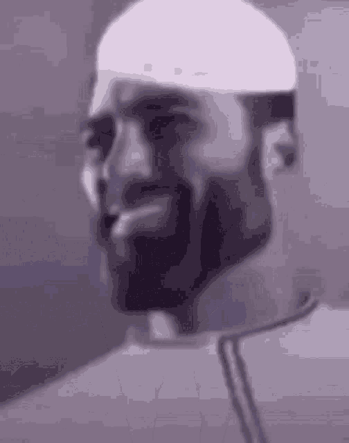 a close up of a man with a beard wearing a white hat .
