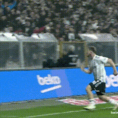 a soccer player is running on a field in front of a beko banner