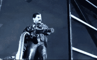 a man in a leather suit is holding a gun in his hand .