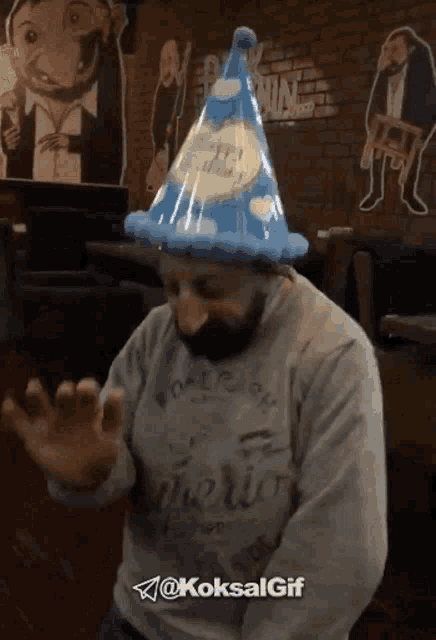 a man with a beard wearing a party hat with the words happy birthday written on it