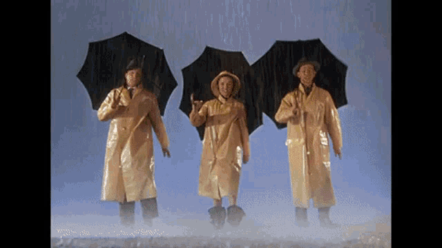 three men in yellow raincoats and hats holding umbrellas in the rain