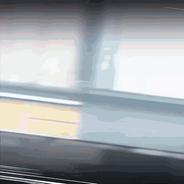 a blurred image of a window with a reflection of a person