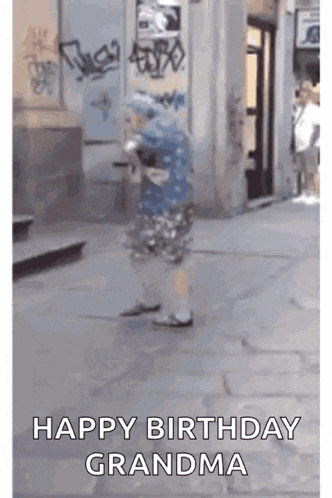 a little girl is walking down a street with the words `` happy birthday grandma '' written on it .