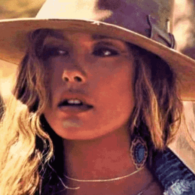 a close up of a woman wearing a cowboy hat