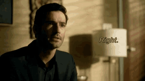 a man in a suit is sitting in front of a lamp and says right