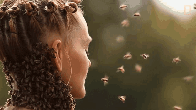 a woman with bees on her hair and neck