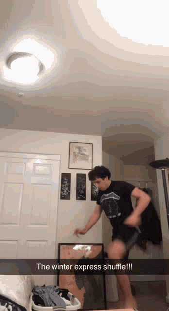 a man in a black shirt is jumping in a room with the words " the winter express shuffle "