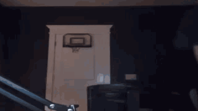 a basketball hoop is hanging on a door in a dark room