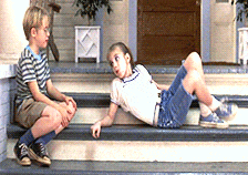 a boy and a girl are sitting on a set of stairs