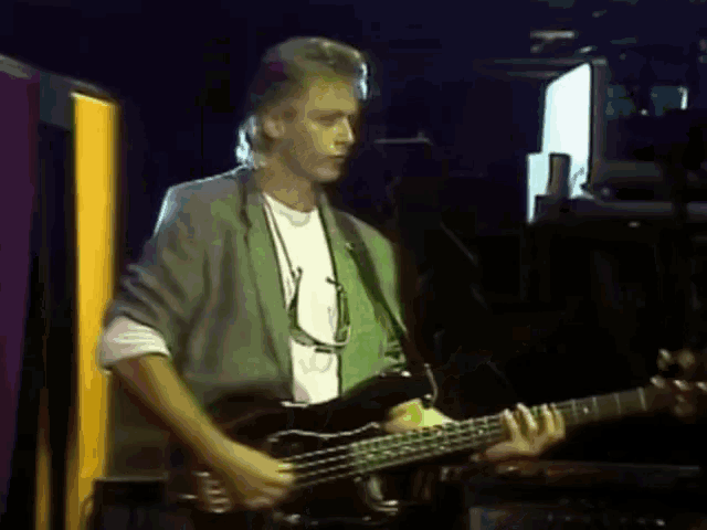 a man is playing a bass guitar on stage