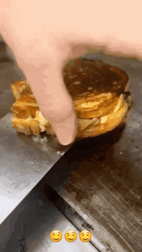 a grilled cheese sandwich is being cut with a knife