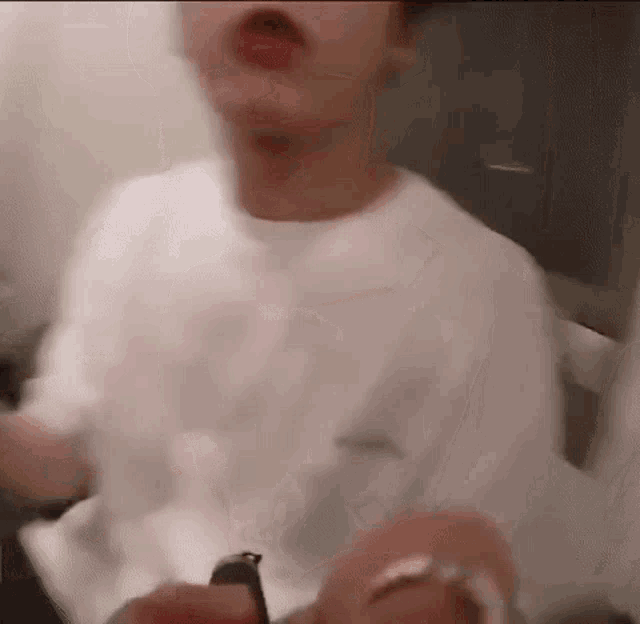 a man in a white shirt is sitting in a chair with his mouth open .