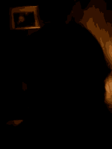 a dark room with a picture on a wall