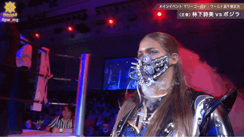 a woman wearing a mask stands in a wrestling ring with chinese writing on the bottom