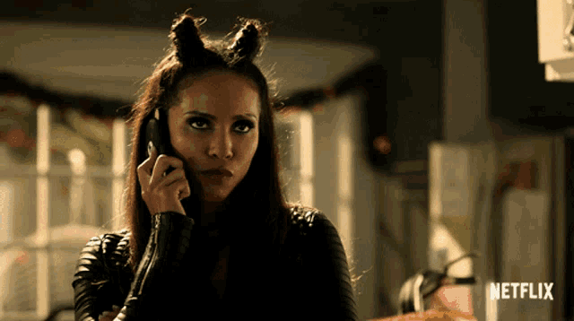a woman talking on a cell phone with a netflix logo in the background