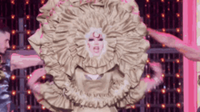 a woman is wearing a very large ruffled dress with a face on it .