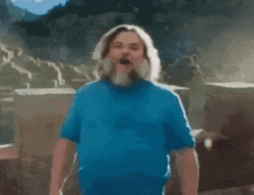 a man with a beard and a blue shirt is standing in front of a sign that says `` i am '' .