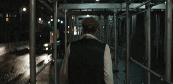 a man in a black vest is walking through a scaffolding